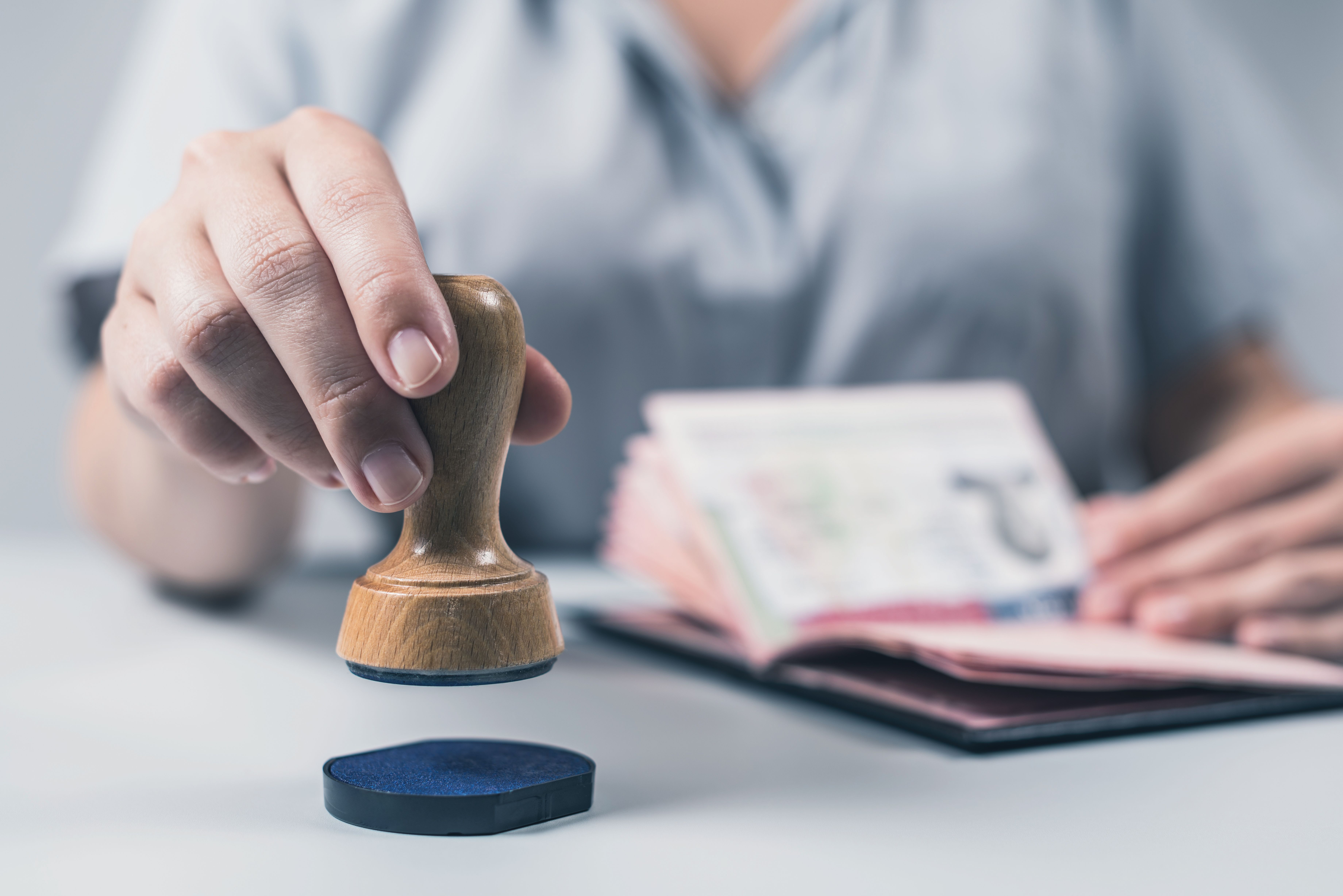 มือทนายกำลังประทับตราเอกสารรับรอง (Notary Public) พร้อมพาสปอร์ต